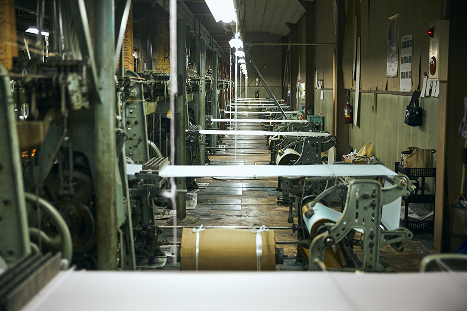 吉村商店の関連会社　吉村機業(株)の工場。44台の織機が稼働する織機音と光景は圧巻。